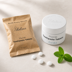 Tidalove fluoride toothpaste tablets packaging with tablets and a mint leaf on a beige background