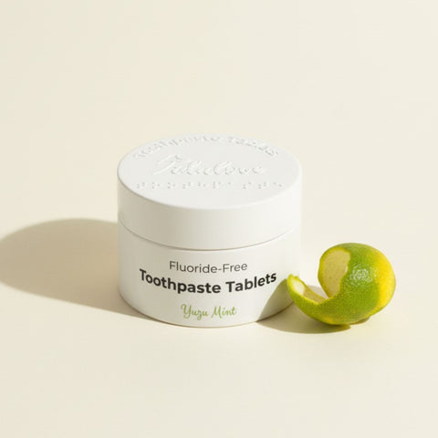 Jar of fluoride-free toothpaste tablets with a lime on a light background