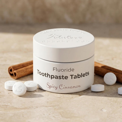 Container of fluoride toothpaste tablets with cinnamon sticks and tablets on a wooden surface