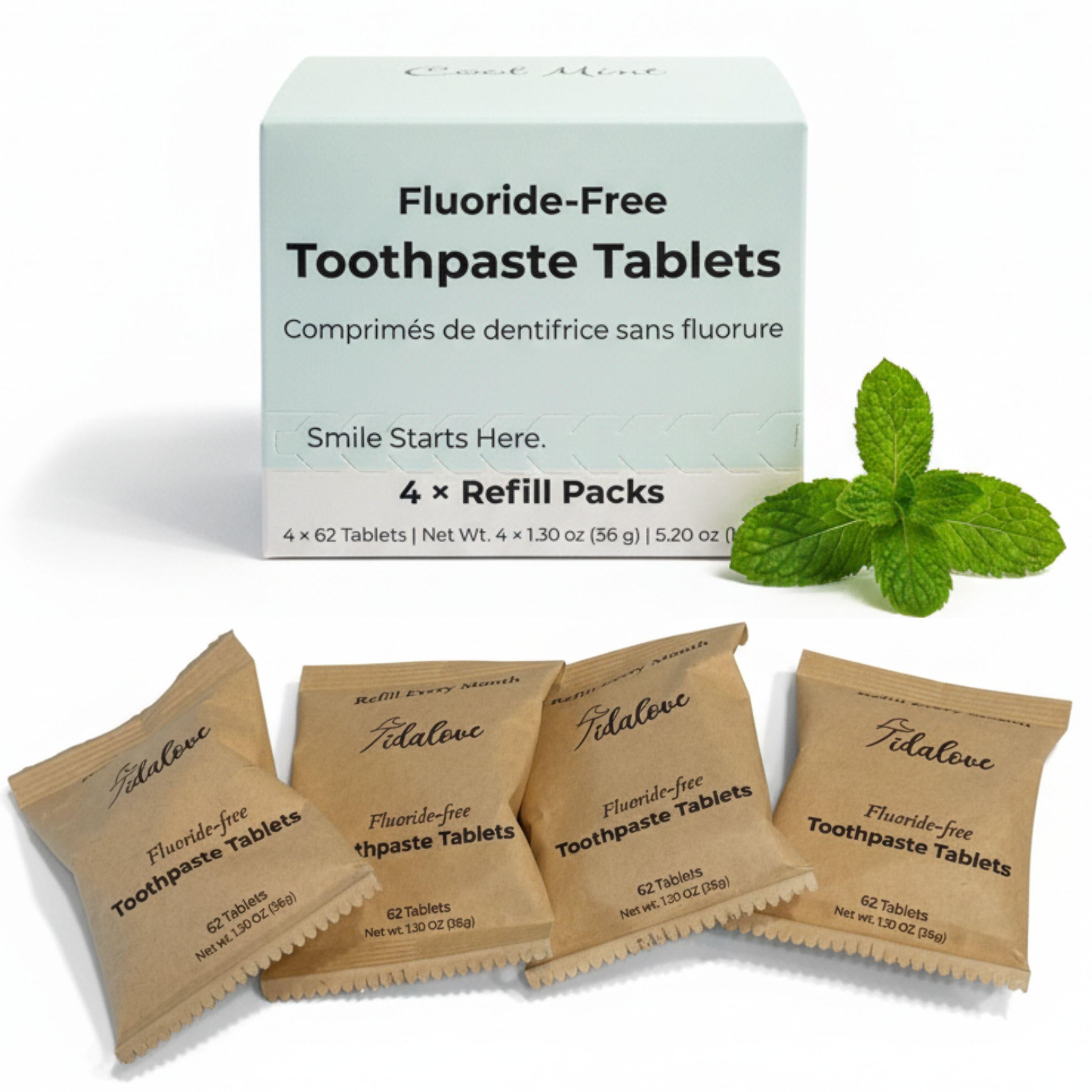 Fluoride-free toothpaste tablets with packaging and mint leaves on a white background