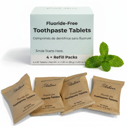 Fluoride-free toothpaste tablets with packaging and mint leaves on a white background