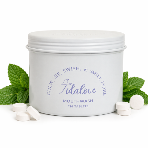 Tidalove mouthwash tablets in a container with mint leaves on a white background